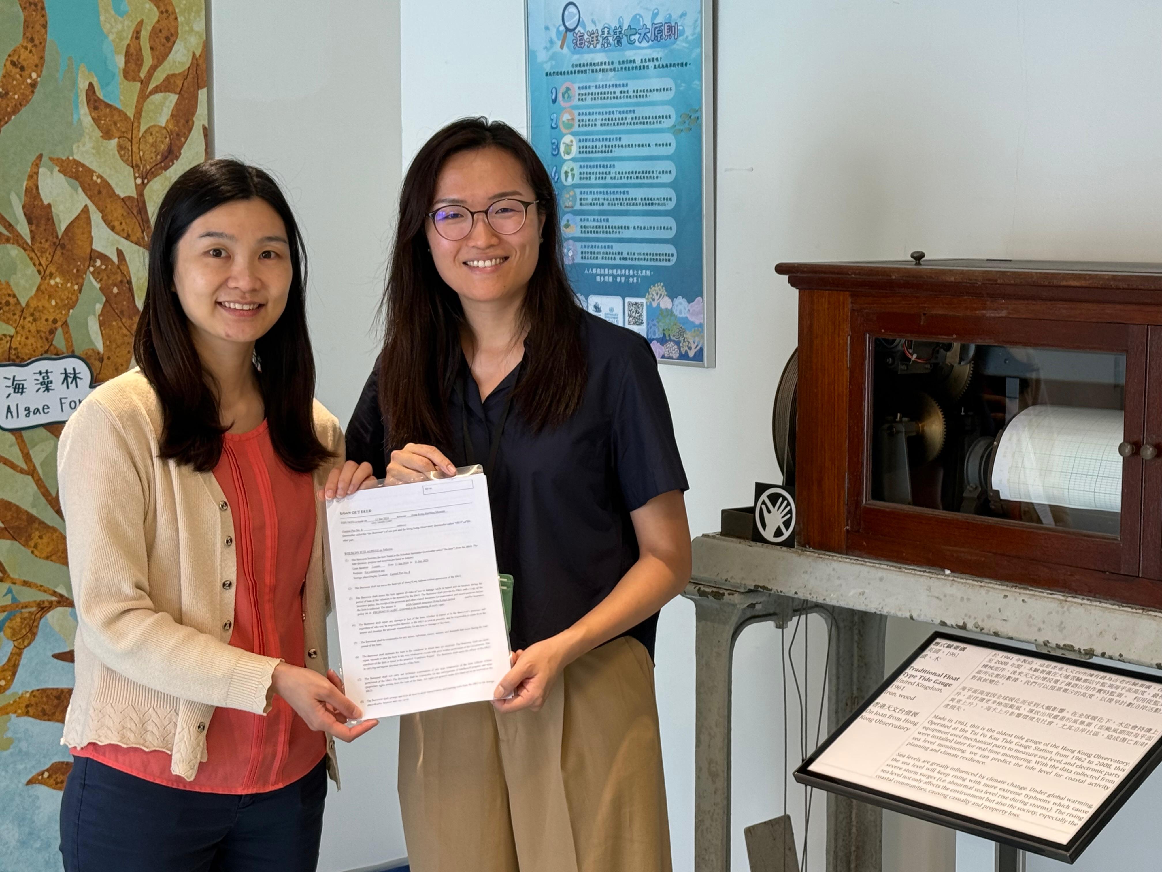 天文台科学主任李凤莹女士（左）向香港海事博物馆海洋探知馆主管伍家恩博士（右）移交验潮仪借展协议书